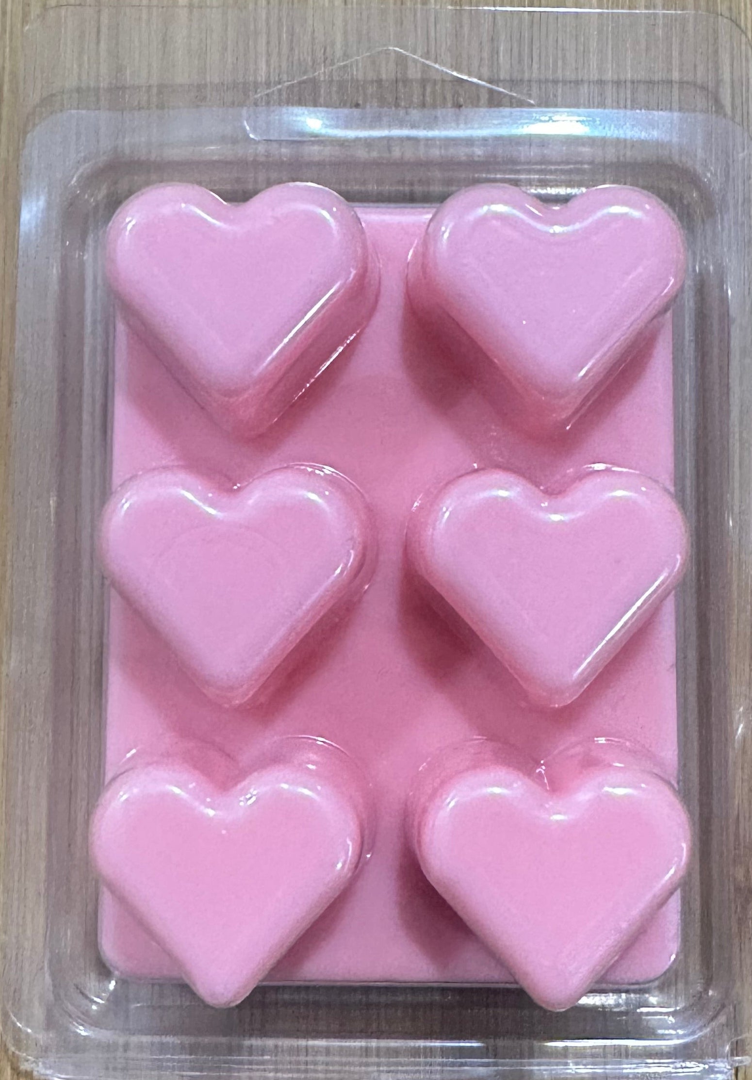 Pink heart-shaped soy wax melts in clear plastic packaging for home fragrance
