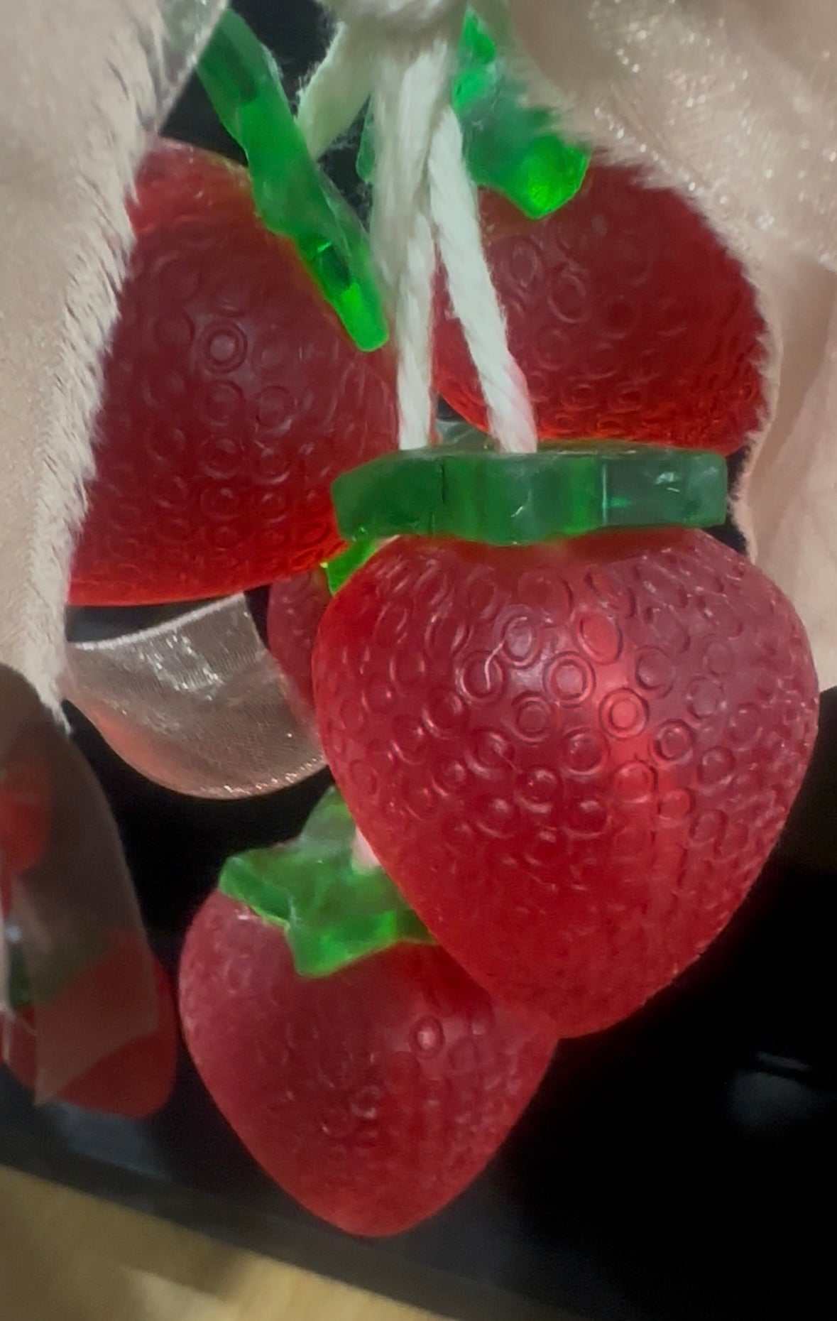 Handcrafted strawberry soap on a rope with realistic red strawberry design and green leaf accents for hanging and decoration