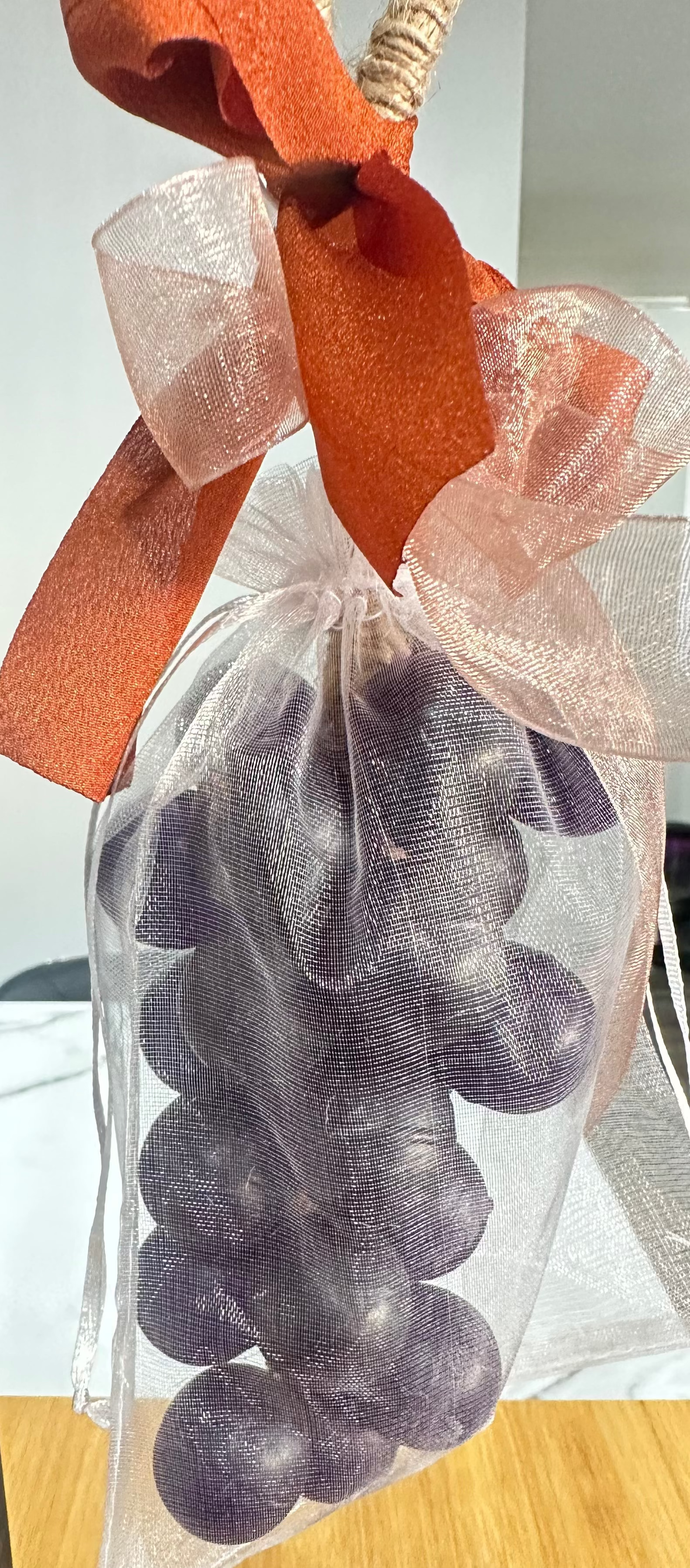 Handcrafted grape cluster soap on a natural jute rope with decorative ribbons, designed for hanging and gentle cleansing.